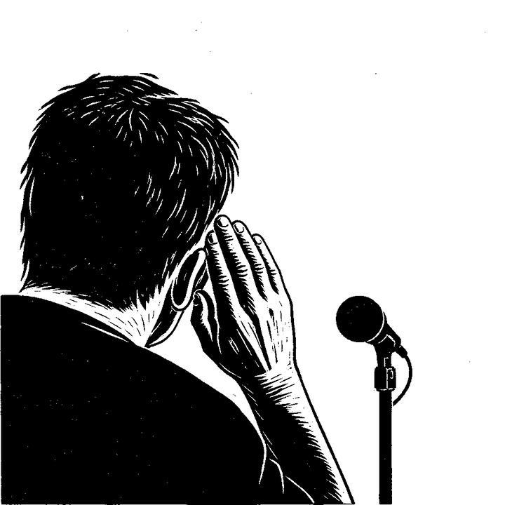 A person seen from behind, a hand cupped to one ear, leaning towards a microphone.
