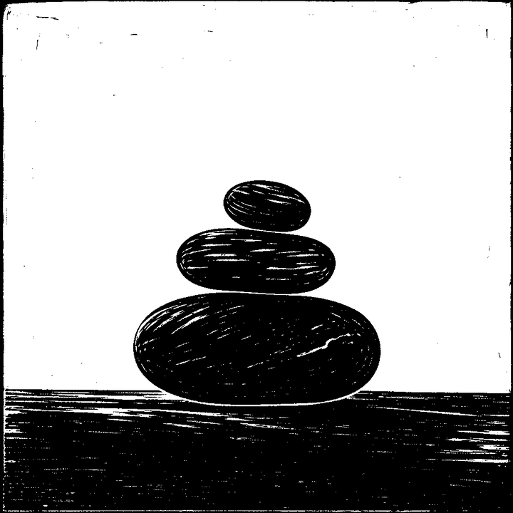 Three stones stacked on a table: small, medium and large.